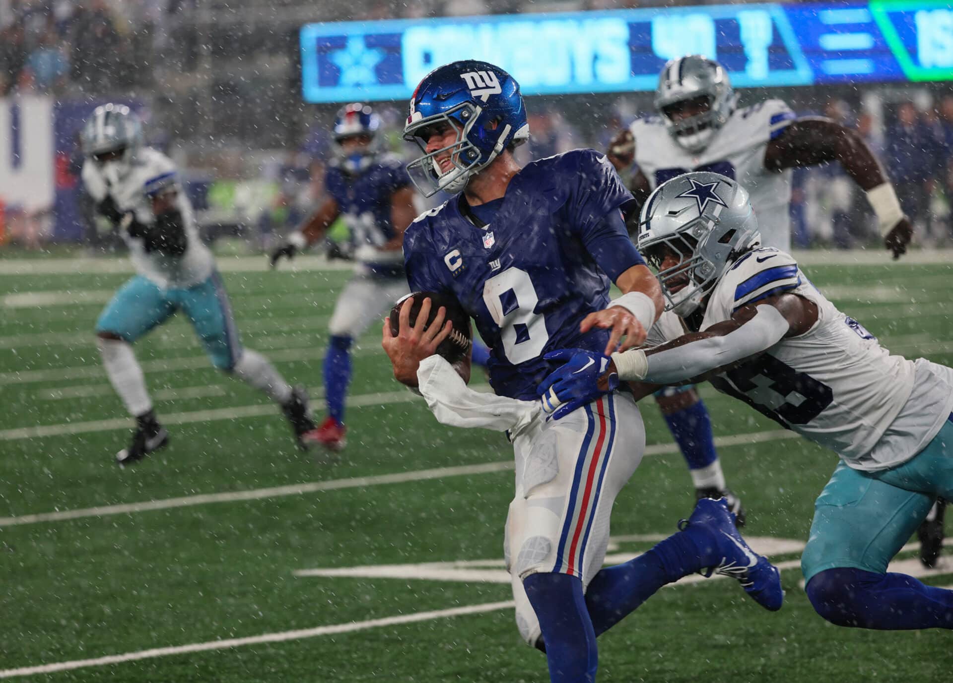 Trailing 40-0 to the Dallas Cowboys, New York Giants quarterback Daniel Jones (8) runs with he ball during a downpour in the fourth quarter on Sunday, September 10, 2023 in East Rutherford, N.J.
