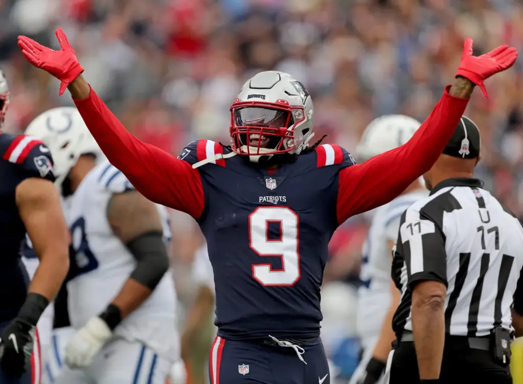 Football player in a Patriots uniform with number 9, raising arms during a game against the Colts.