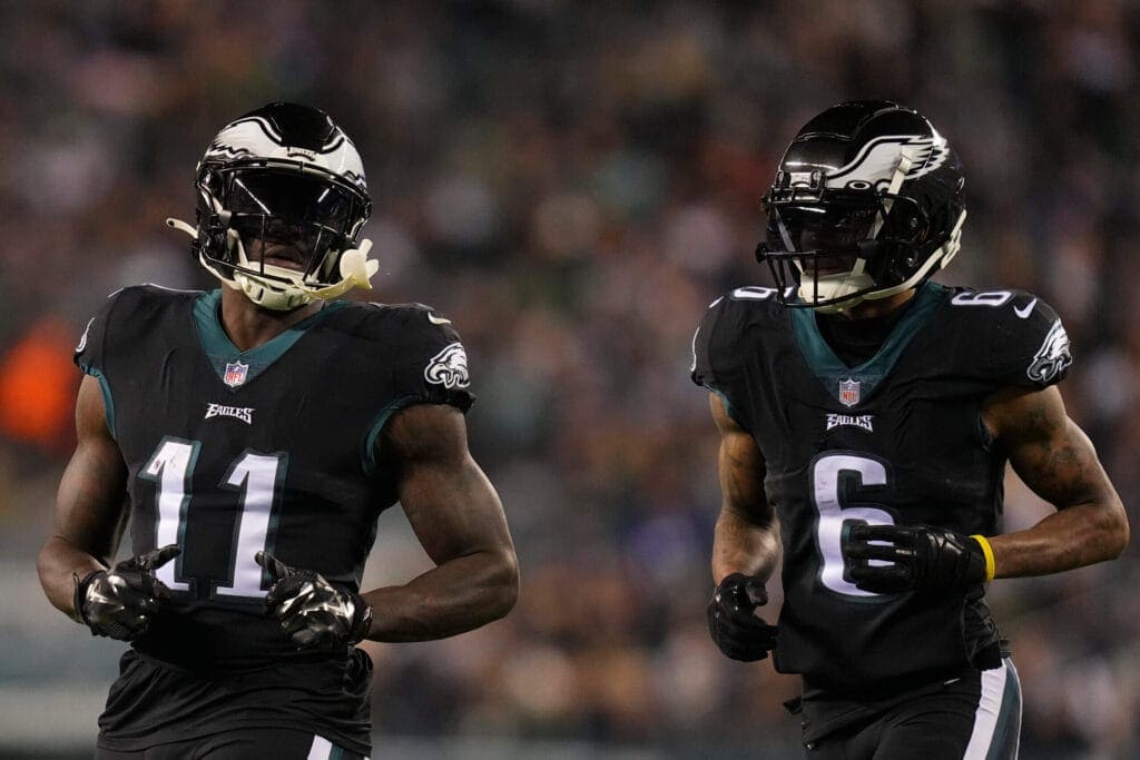 NFL football players from the Philadelphia Eagles team wearing black jerseys and helmets during a game, showcasing players number 11 and 6, in action on the field.