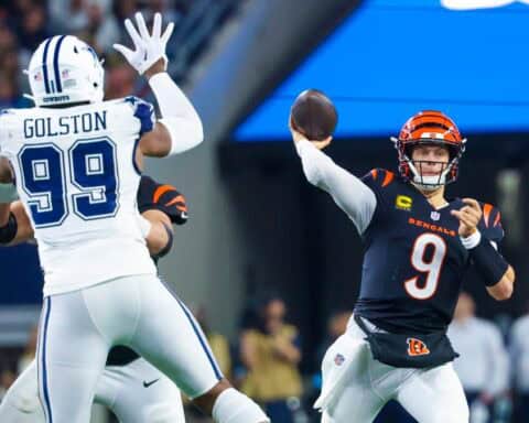 Cincinnati Bengals quarterback throwing a football against the Dallas Cowboys defense during an NFL game. Focus on action-packed moment showcasing team rivalry and football excitement.