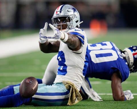 Solid football player making a play on the field during a game; Dallas Cowboys player in action against an opposing team.