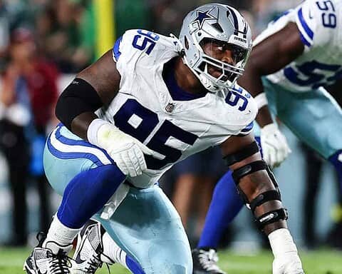 Aggressive Dallas Cowboys football player in action during game on the field.