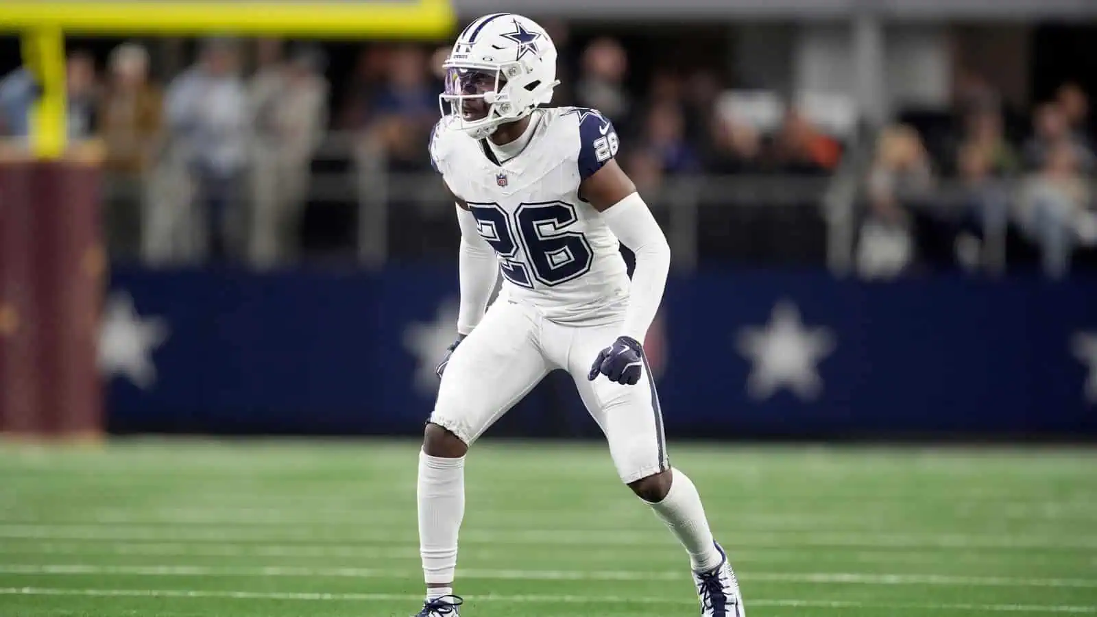 High-quality image of a Dallas Cowboys football player in action during a game, wearing white uniform and helmet with star logo, on the field with fans in the background, emphasizing NFL football and Cowboys team spirit.