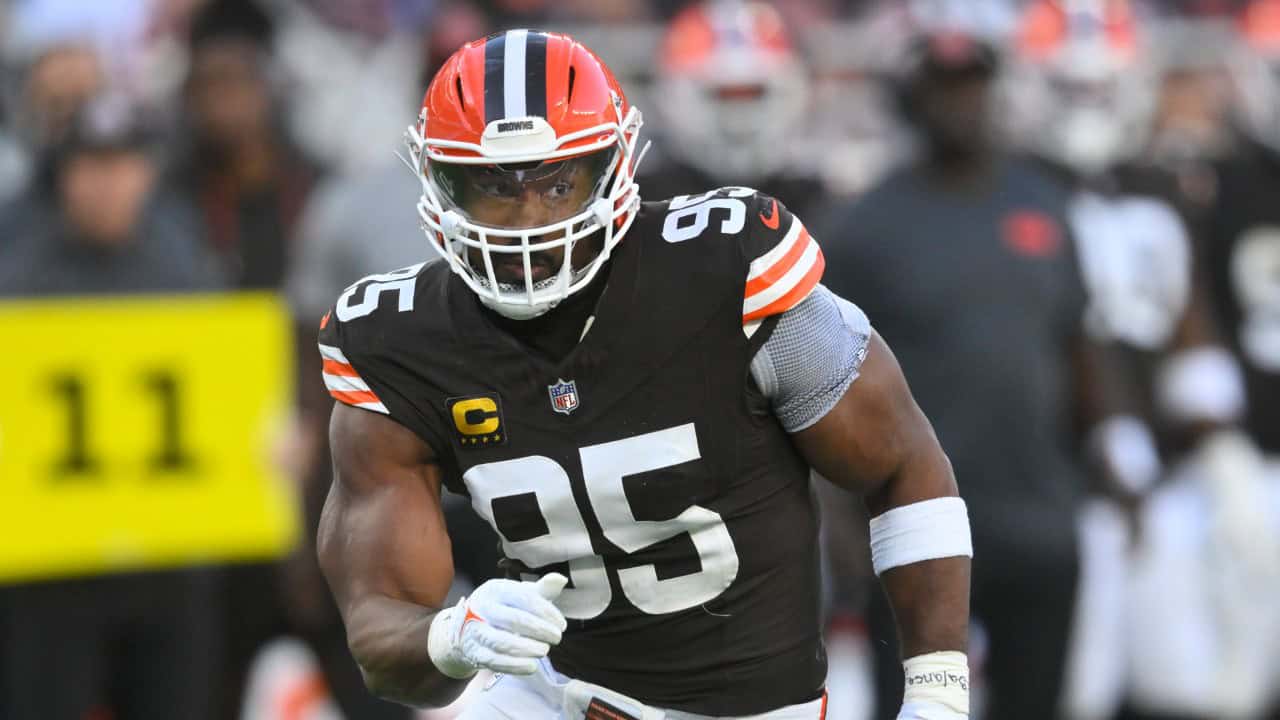 Deep Cleveland Browns football player during a game, wearing uniform number 95, running on the field with stadium crowd in background.