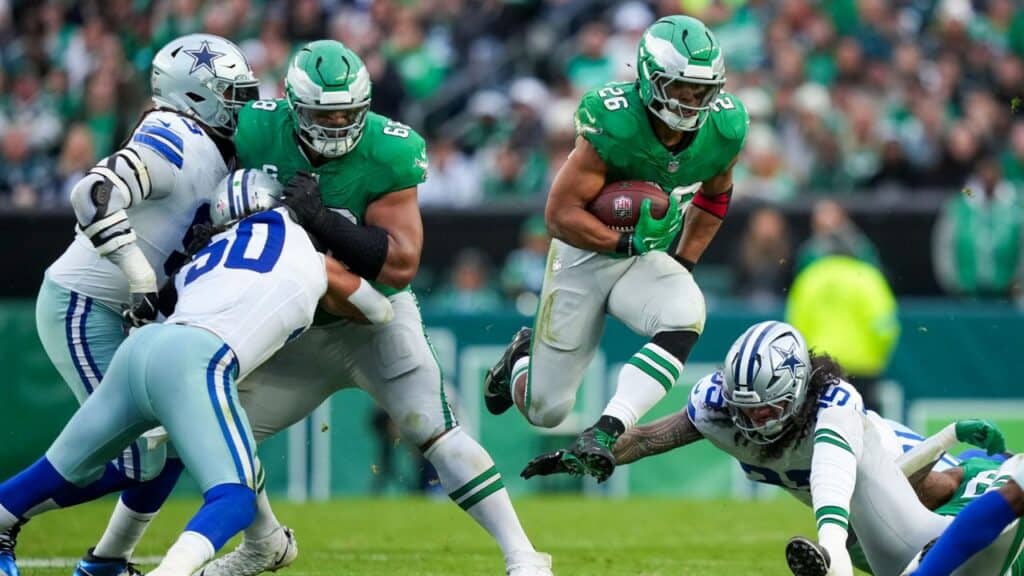A dynamic action shot of NFL players during a game between the Dallas Cowboys and New York Jets, showcasing intense tackles, rushing plays, and athleticism on a vibrant football field packed with fans.