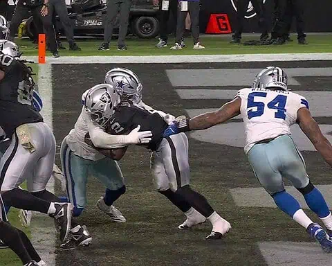 Helmets and jerseys of Dallas Cowboys and Las Vegas Raiders players during an NFL game.
