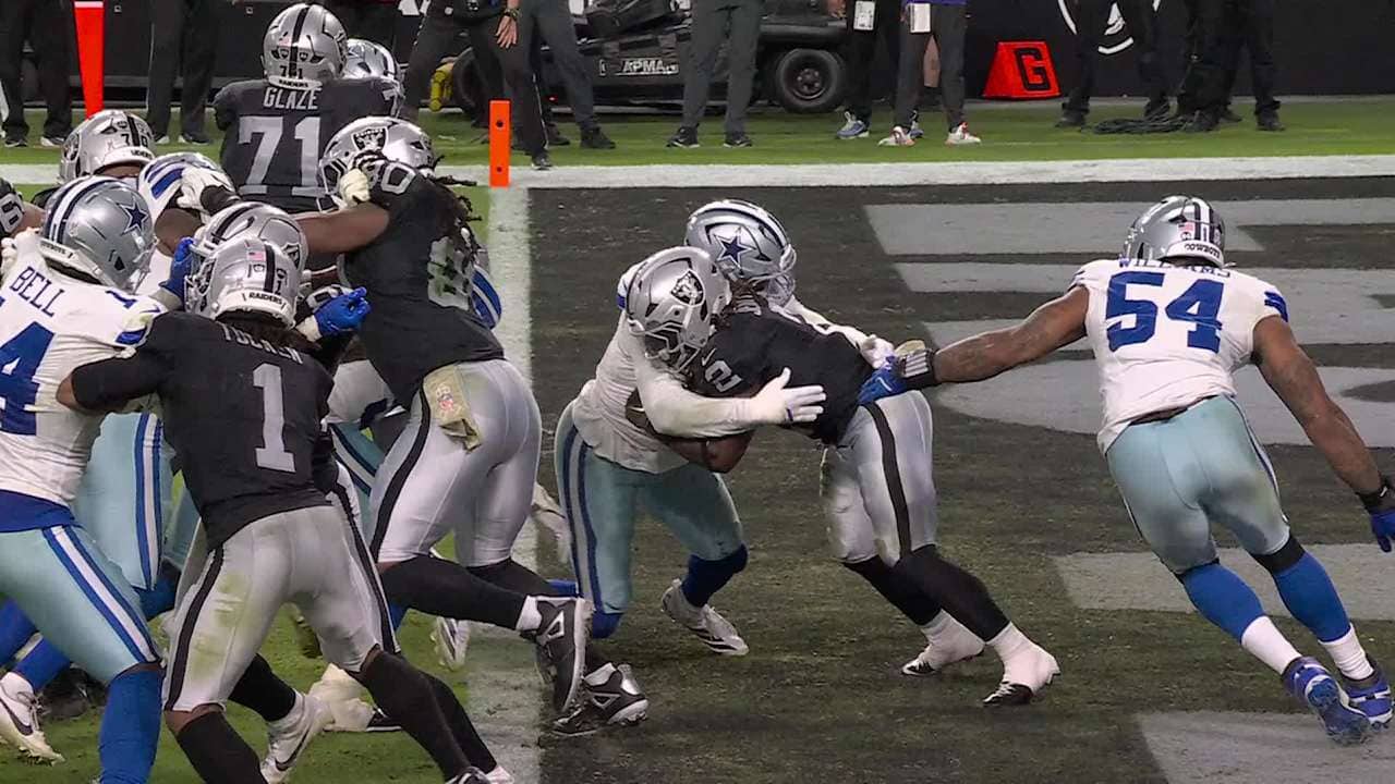 Helmets and jerseys of Dallas Cowboys and Las Vegas Raiders players during an NFL game.