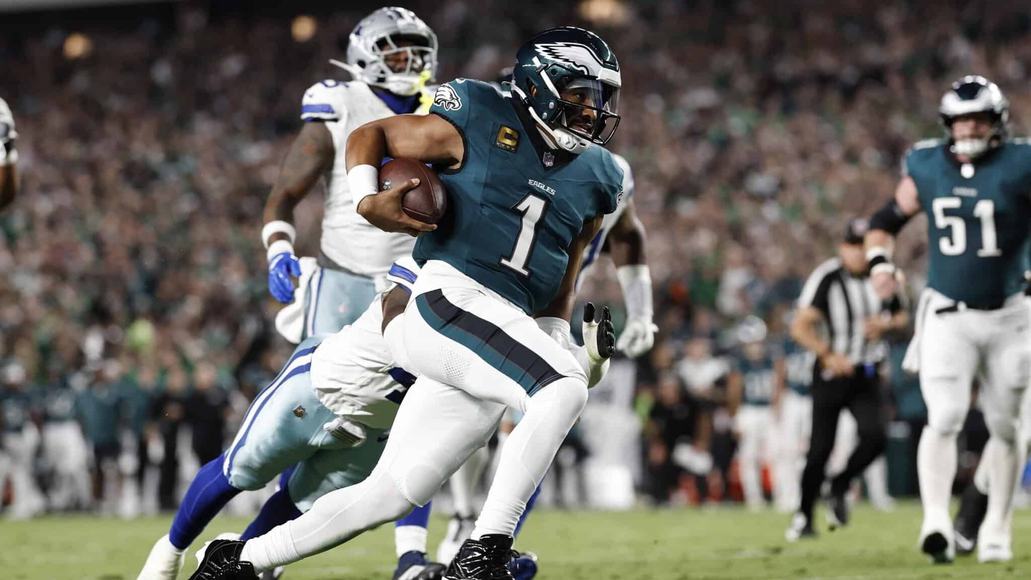Running back with jersey number 1 carrying football, defensive players in background, game action, Philadelphia Eagles team, NFL football game, stadium crowd in background, inside the star.