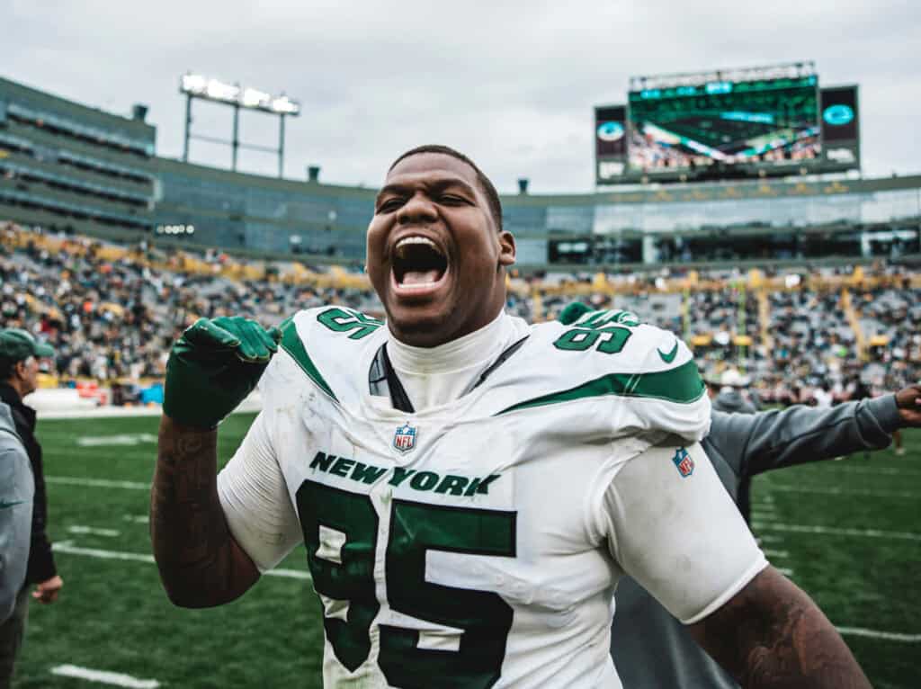High-energy football player celebrating on the field during an NFL game with the New York Jets, showcasing passion, team spirit, and inside insight from Inside The Star.