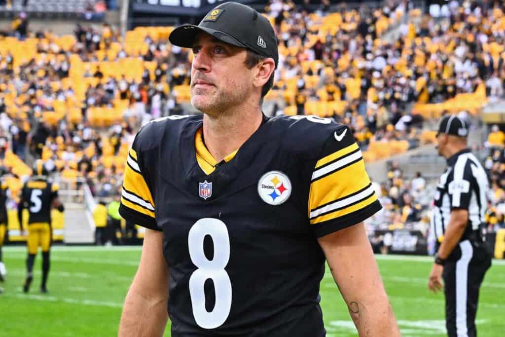 Close-up of Tom Brady in a Steelers uniform on the football field, highlighting his focused expression amidst the crowd, emphasizing sports passion and NFL action.
