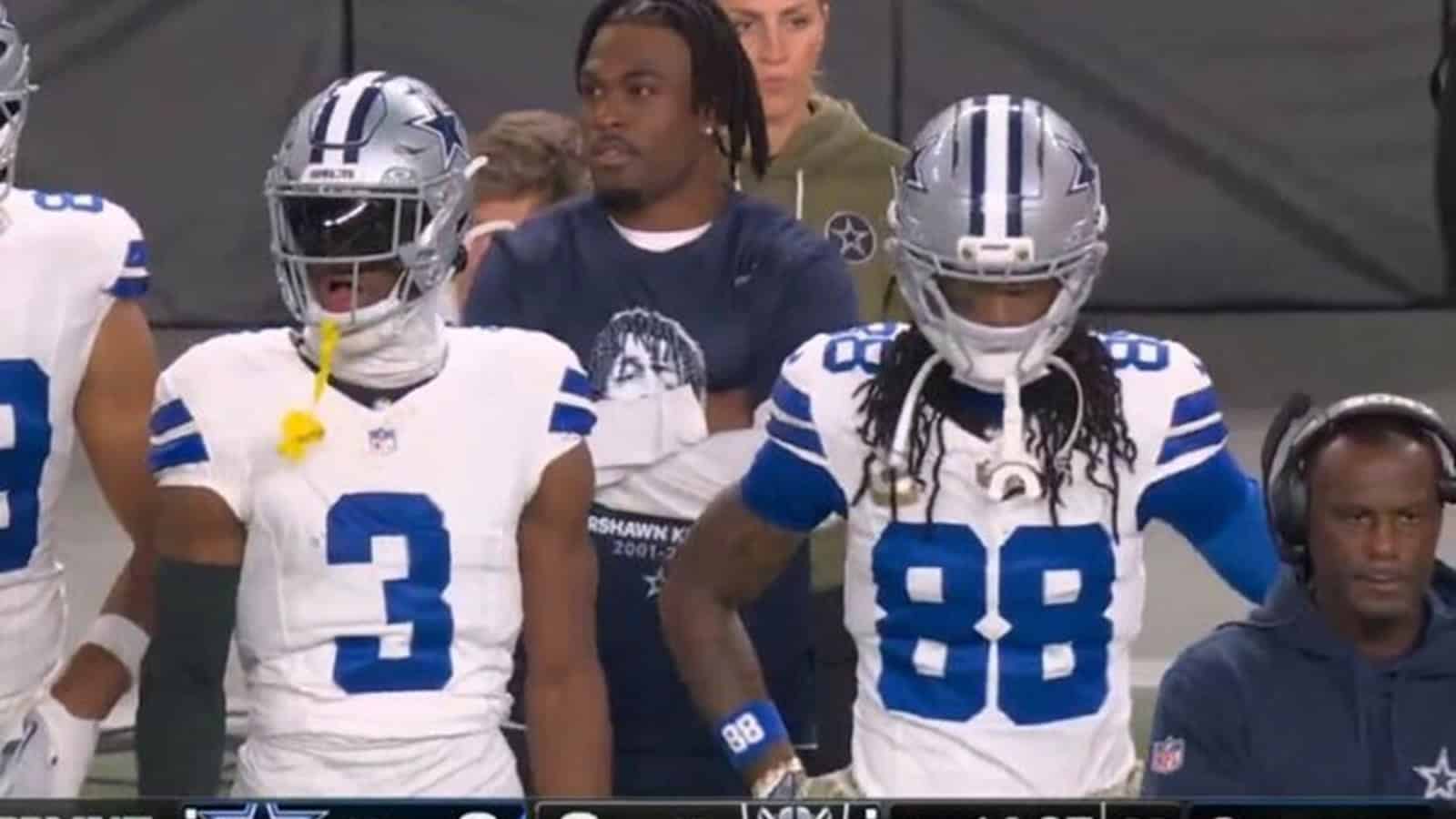 Detailed image of Dallas Cowboys football players wearing team uniforms during a game, capturing team members, coaching staff, and fans in the background, highlighting NFL team spirit and game-day atmosphere.