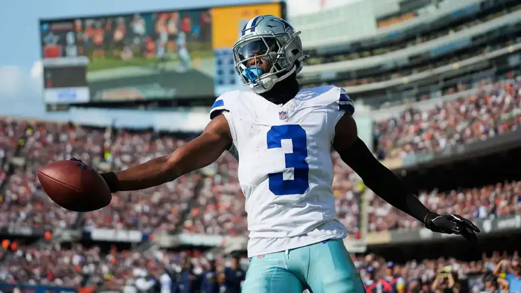 Dallas Cowboys football player holding the ball in stadium during game day, representing NFL football, athletic performance, and sports fan enthusiasm.