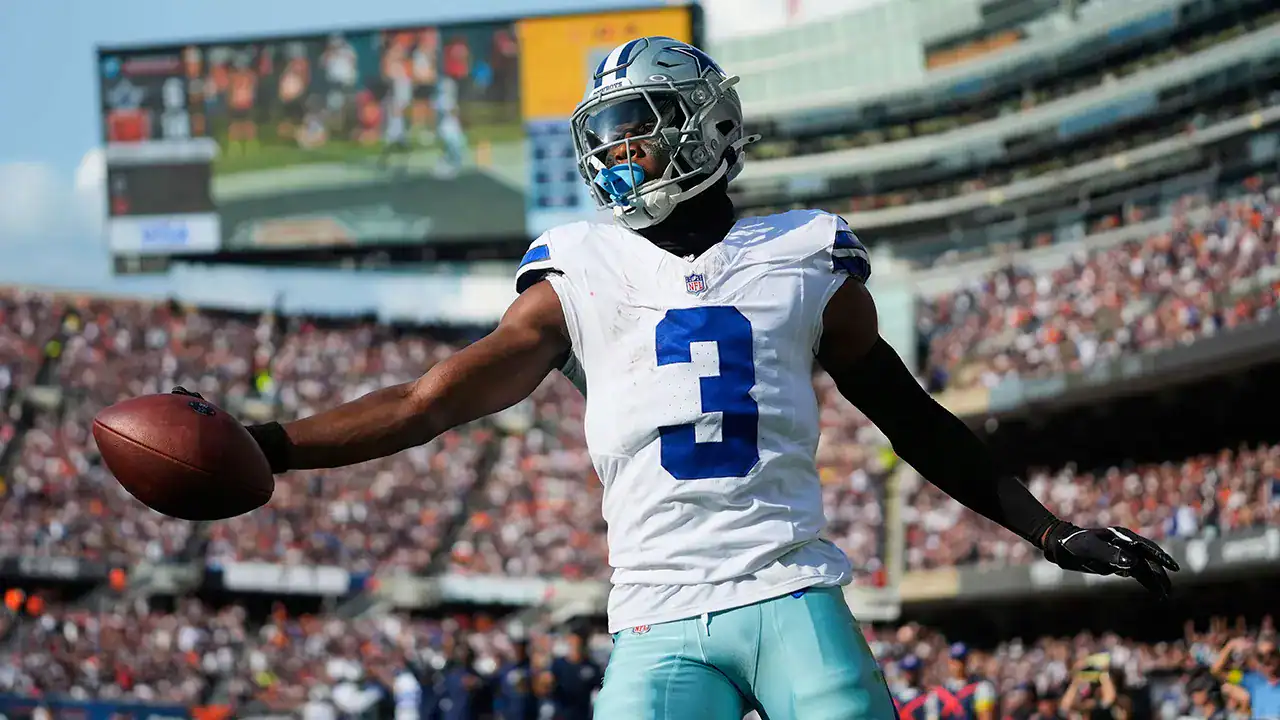 Dallas Cowboys football player holding the ball in stadium during game day, representing NFL football, athletic performance, and sports fan enthusiasm.