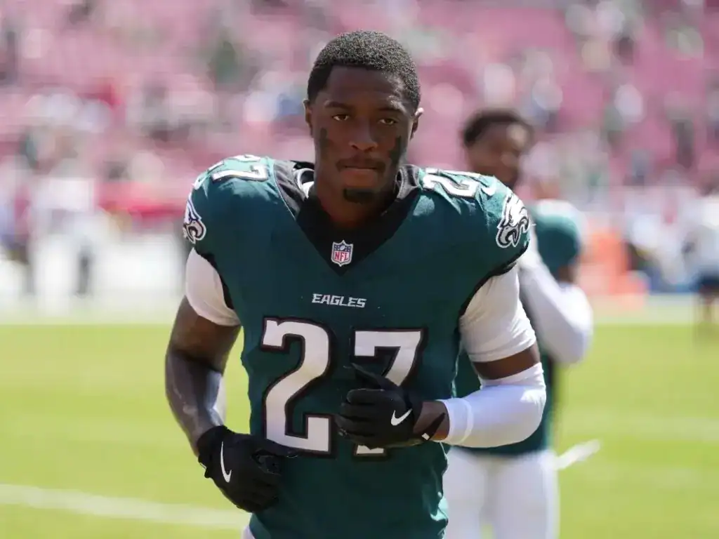 A professional football player from the Philadelphia Eagles, wearing jersey number 27, is captured on the field during a game, showcasing athleticism and team spirit.