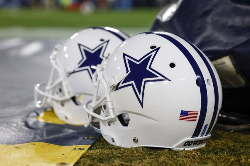 Dallas Cowboys white NFL helmet on the football field representing America's Team and offseason salary cap strategy.