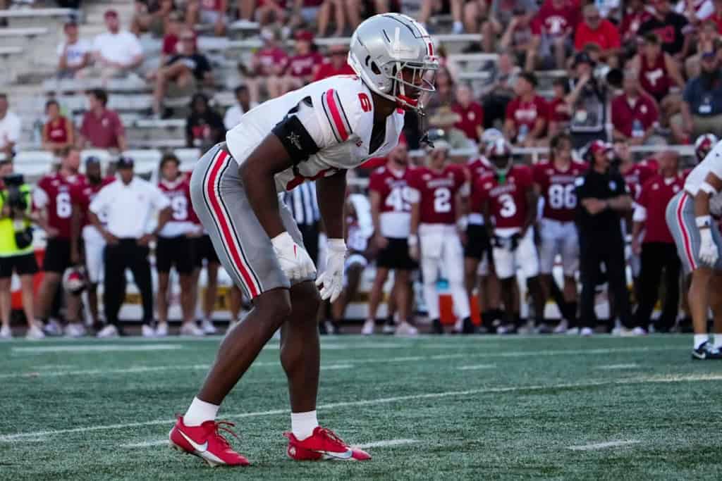 Sonny Styles stands ready at linebacker for Ohio State, focused before the snap with the opposing offense aligned.