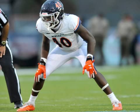 Morgan State Bears linebacker, Erick Hunter, wearing a white No. 40 uniform lines up in a low defensive stance during a game as a referee stands nearby on the field.