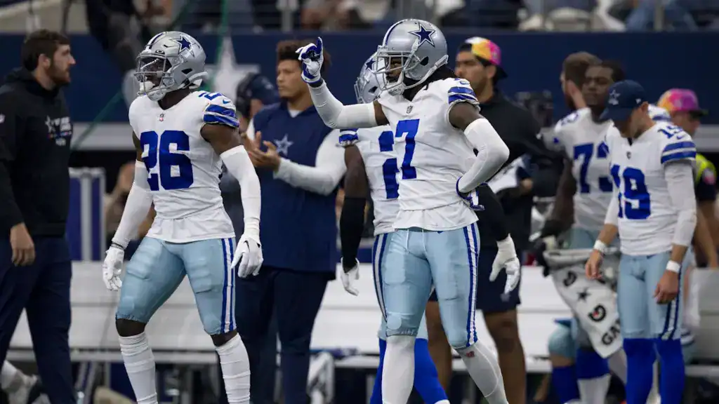 Dallas Cowboys defenders stand on the sideline during a game, a unit expected to evolve under defensive coordinator Christian Parker’s aggressive philosophy.