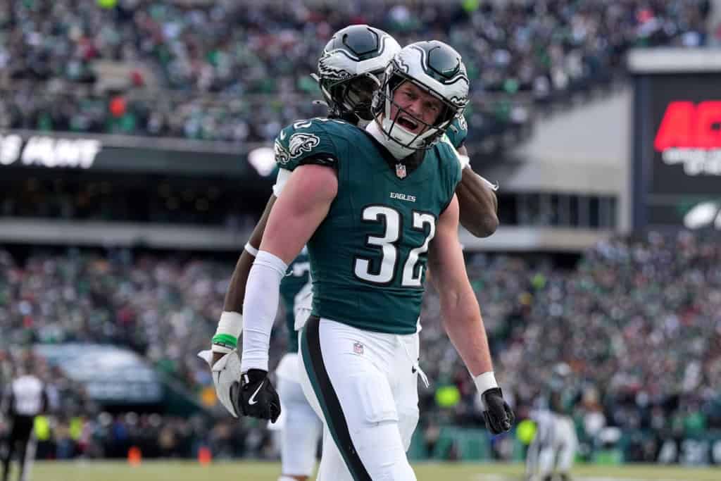 Philadelphia Eagles soon-to-be free agent wearing a green No. 32 jersey reacts emotionally on the field after a big play, with a packed stadium crowd in the background.
