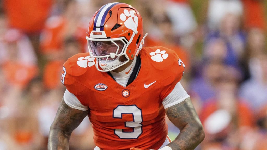 Clemson Tigers defensive lineman wearing an orange No. 3 jersey lines up pre-snap during a night game, featured in Senior Bowl scouting and draft analysis.