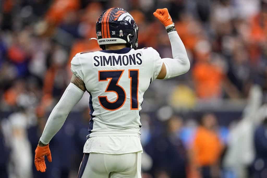 Denver Broncos safety Justin Simmons (#31) raises his fist in celebration, showcasing the strength and leadership of the Broncos secondary during an NFL game.