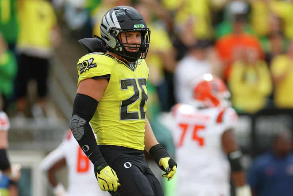 Oregon Ducks linebacker wearing No. 28 stands ready pre-snap during a Pac-12 matchup.