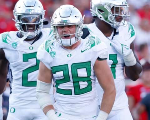 Oregon Ducks linebacker wearing No. 28 fires up teammates during a road game against a ranked opponent.