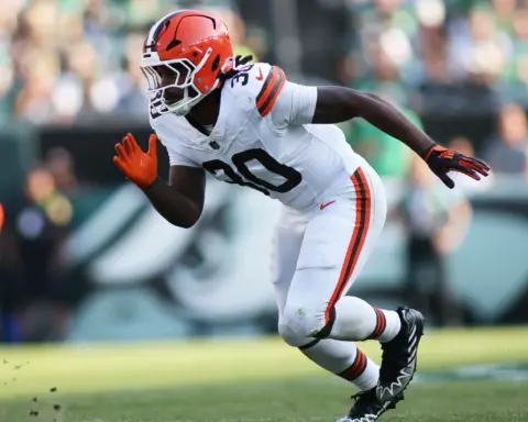 Cleveland Browns linebacker in white uniform accelerating off the line of scrimmage during an NFL game, free agent linebacker action shot.