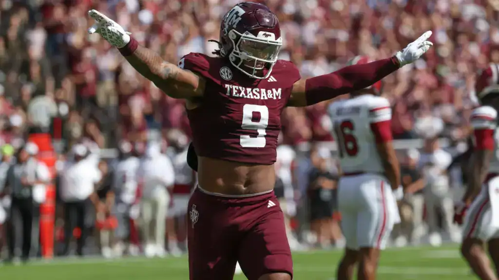 Texas A&M defensive lineman Cashius Howell celebrates a big play during an SEC game, highlighting his mock draft stock as a disruptive edge prospect.