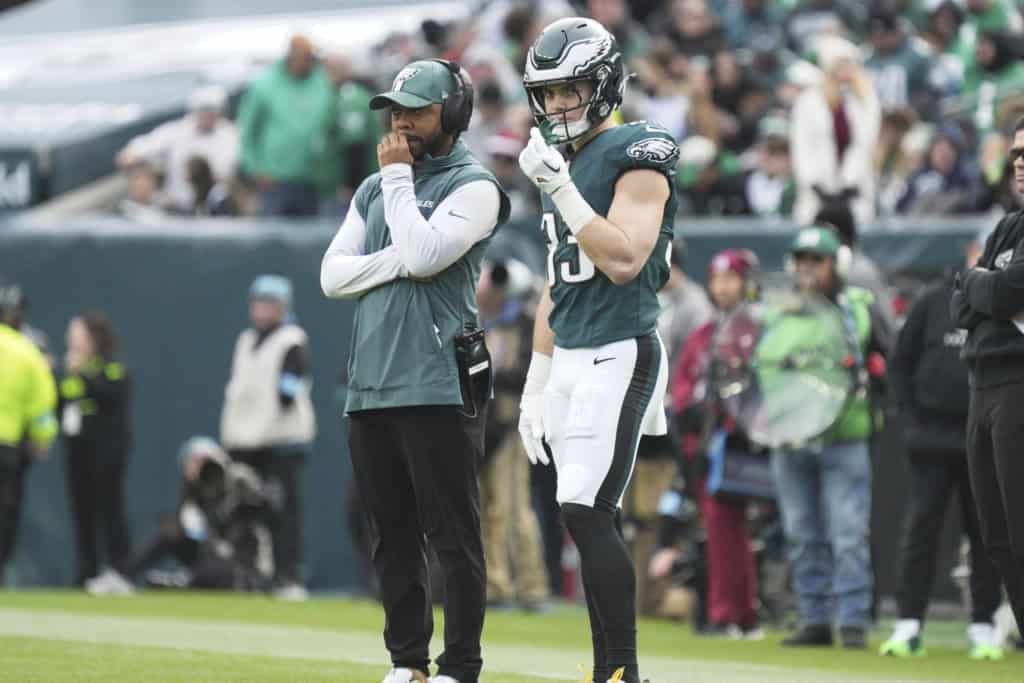 Coach Christian Parker standing on the sideline during an NFL game, observing defensive personnel and communicating coverage adjustments.