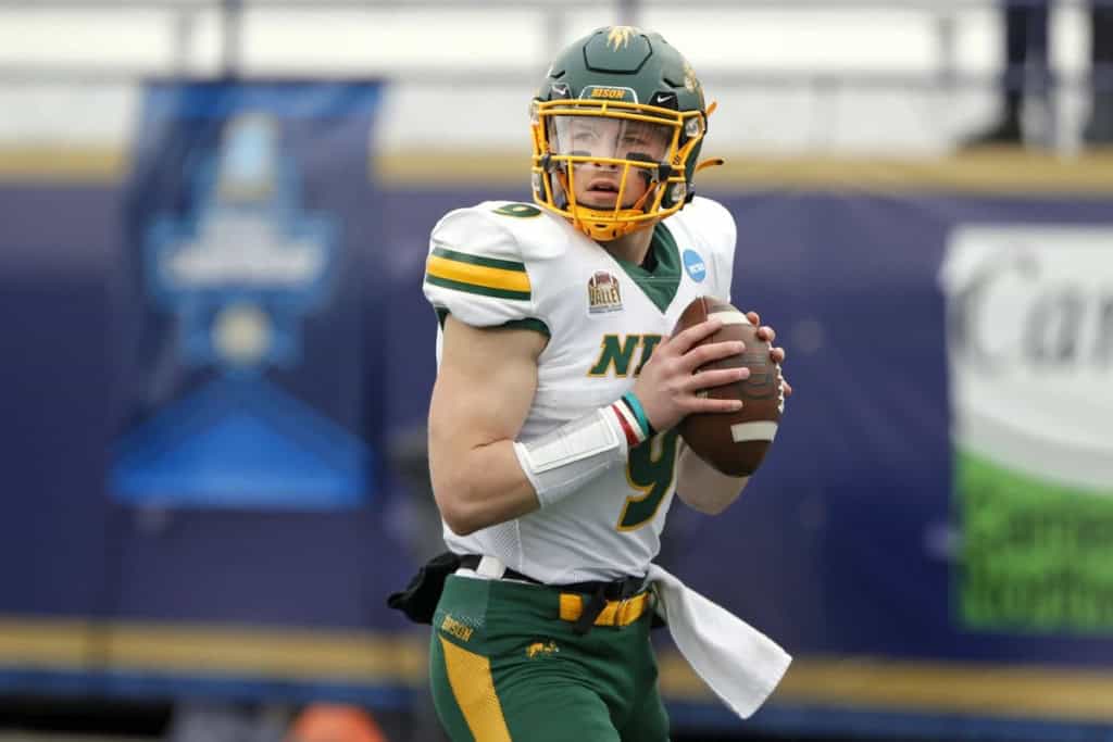 North Dakota State Quarterback stands in the pocket with both hands on the ball, scanning the field.
