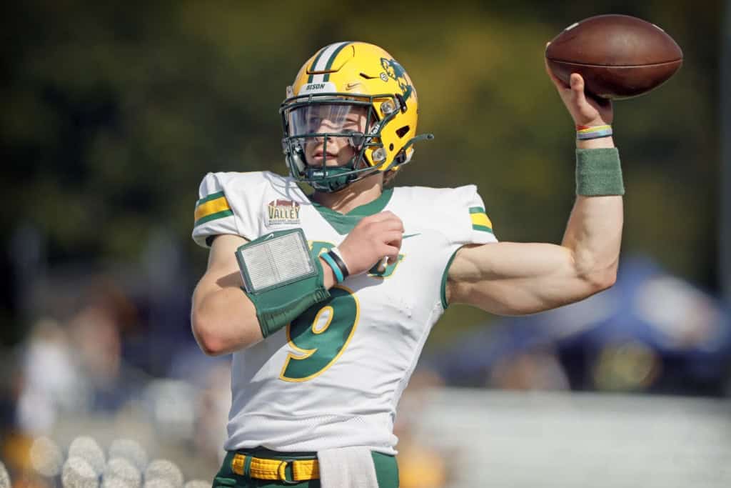 North Dakota State Quarterback winds up to throw a pass, displaying arm strength and mechanics during a college football game.