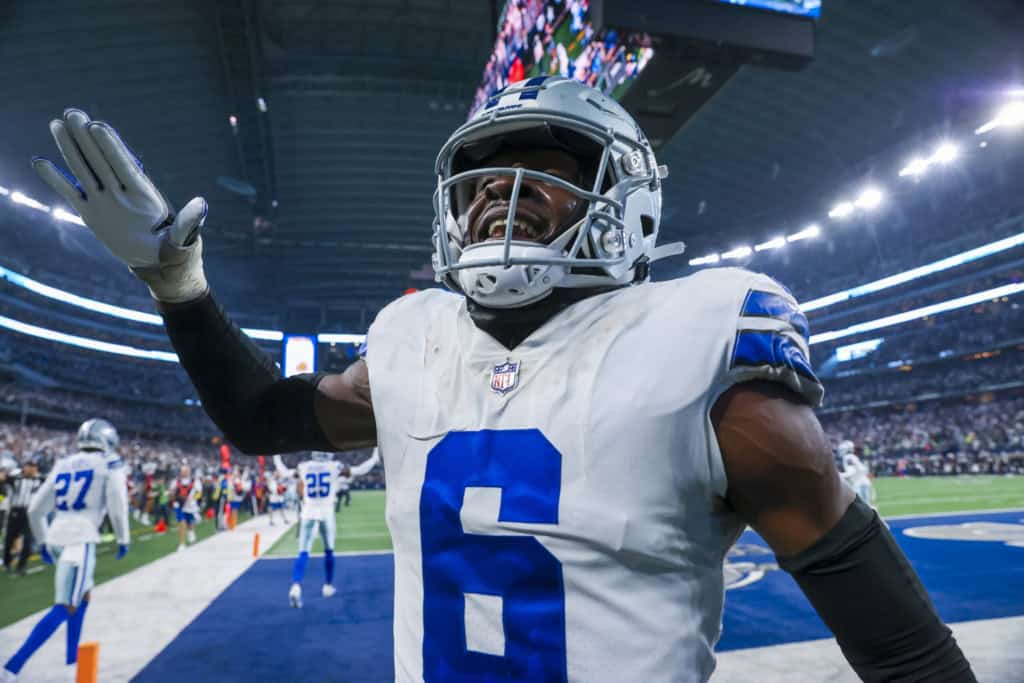 Dallas Cowboys cornerback gestures to teammates after a play against the New York Giants, not reflecting the aggressive coverage style emphasized by Christian Parker.