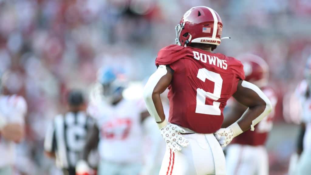 Alabama defensive back Caleb Downs wearing a crimson red No. 2 jersey lines up in coverage before the snap, featured in a Mock Draft discussion of defensive prospects.