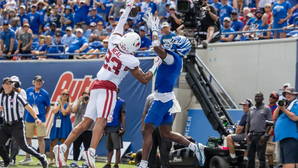 Arkansas Razorbacks defensive back wearing a white No. 25 jersey breaks up a pass along the sideline, shown in a Mock Draft evaluation of cornerback prospects.