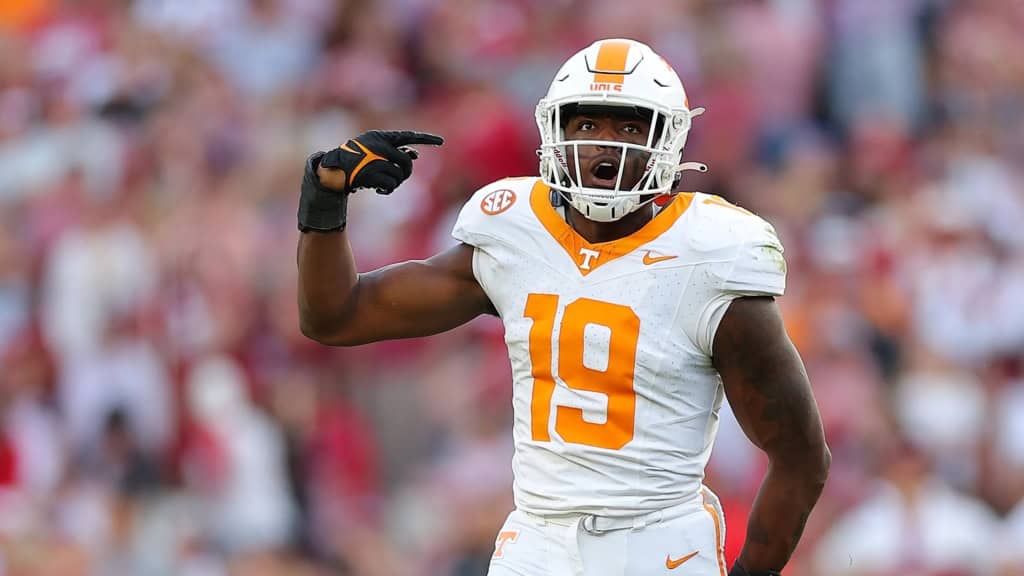 Joshua Josephs (#19) in Tennessee’s white road uniform pointing to his head in celebration, reacting confidently after making a key play on the road.