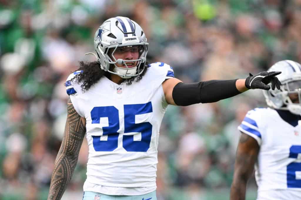 Marist Liufau in a white Cowboys uniform pointing and directing teammates against the New York Jets.