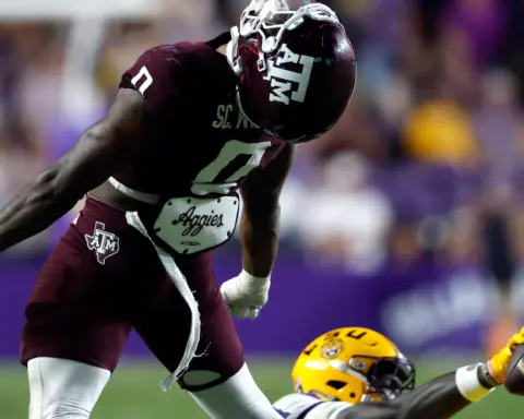 Scooby Williams celebrating a big defensive play for Texas A&M, standing over a loose football during a high-energy SEC game.