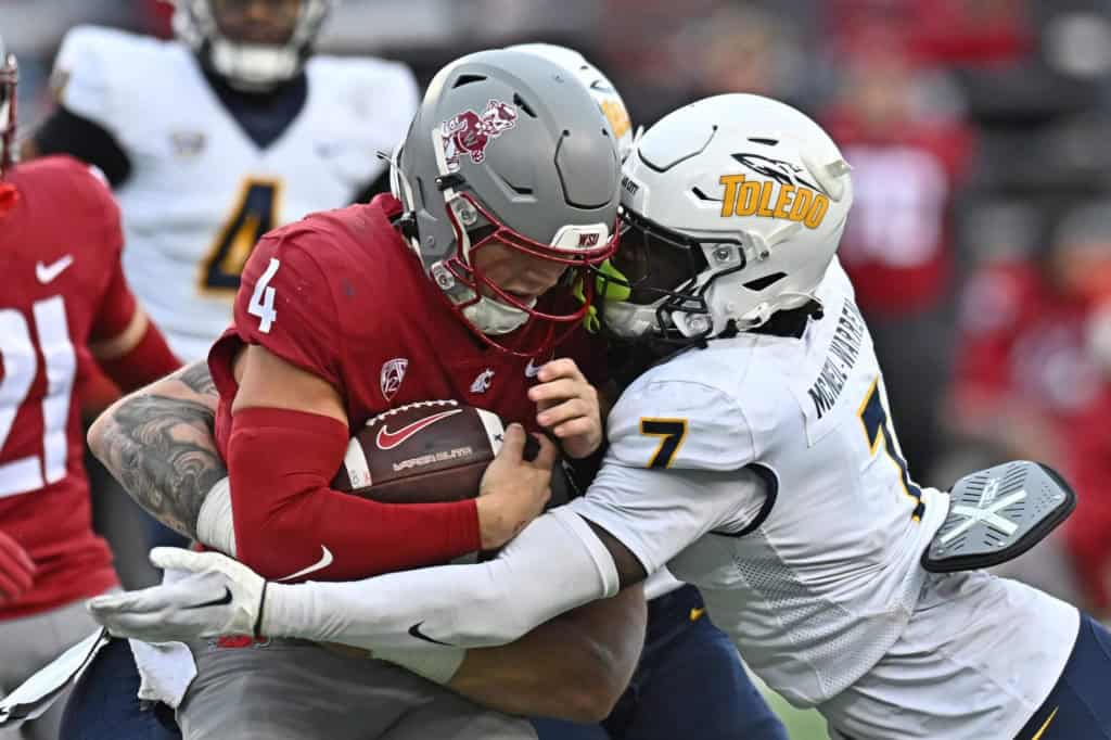 Emmanuel McNeil-Warren wraps up Washington State quarterback for a tackle during a physical college football matchup.