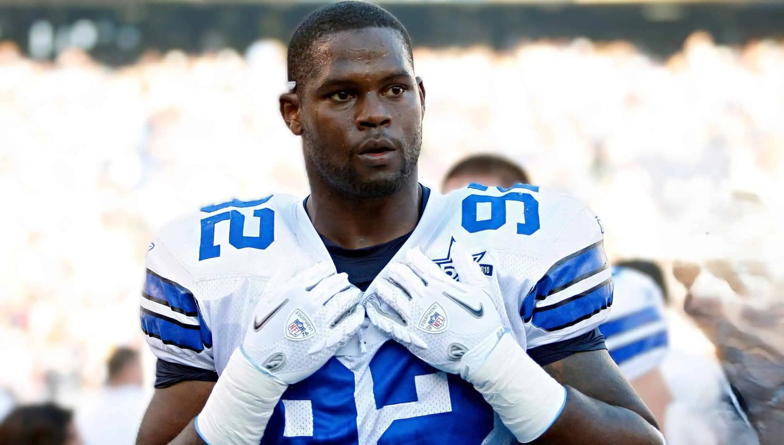 Marcus Dixon in a Dallas Cowboys uniform wearing number 92, adjusting his gloves before an NFL game.