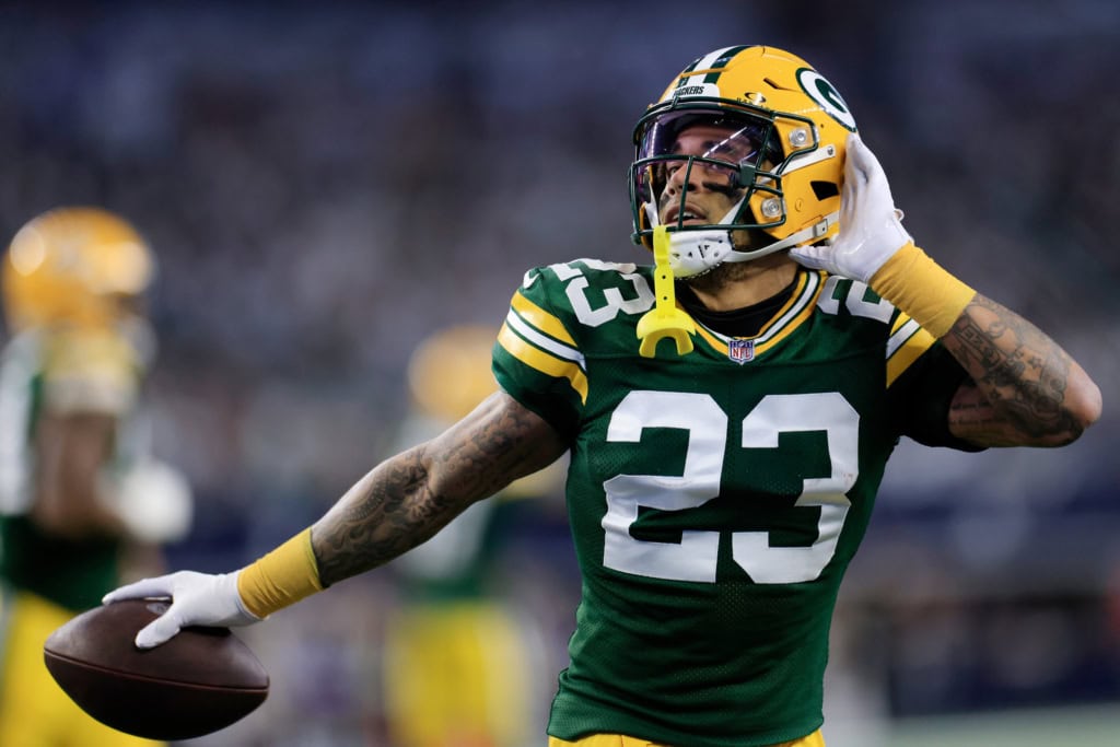 Former Green Bay Packers cornerback Jaire Alexander (#23) celebrates with the football, highlighting the playmaking ability of the Packers secondary in action.