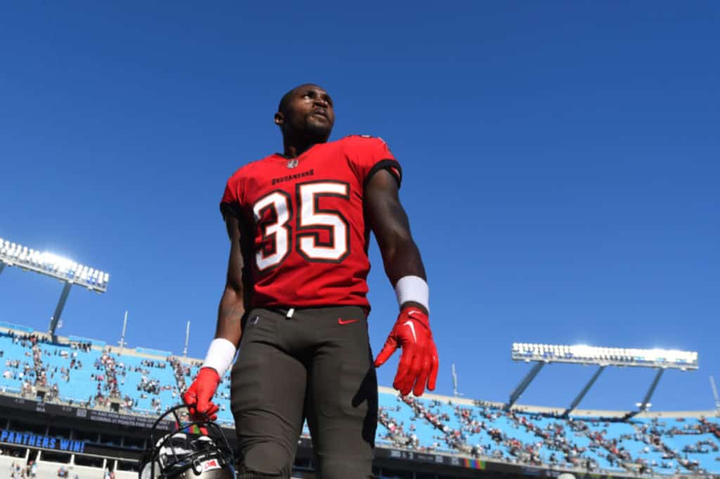 Tampa Bay Buccaneers defensive back from the secondary walks off the field holding his helmet after an NFL game.