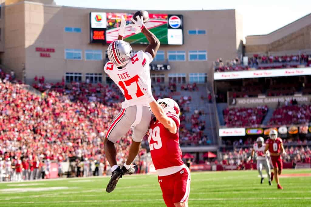 Ohio State wide receiver Carnell Tate rises above a Wisconsin defender to make a contested catch during a college football game.