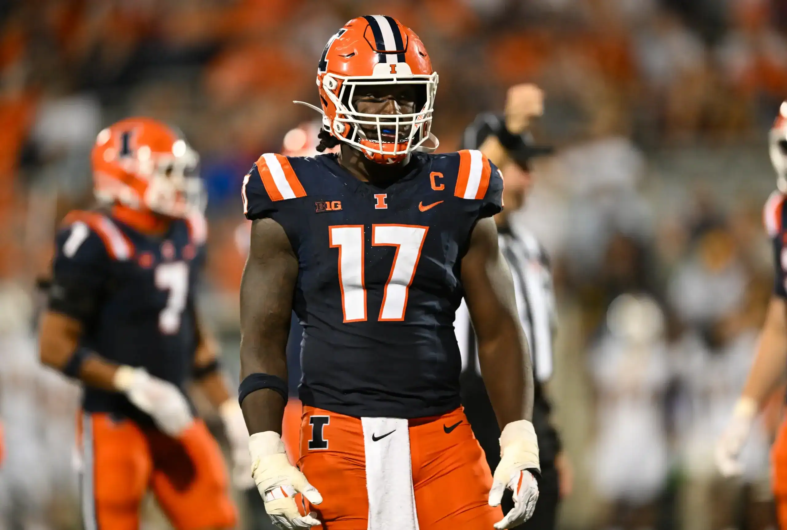 Illinois linebacker No. 17 stands poised pre-snap under the lights, highlighted as a defensive prospect in a 2026 NFL Mock Draft.