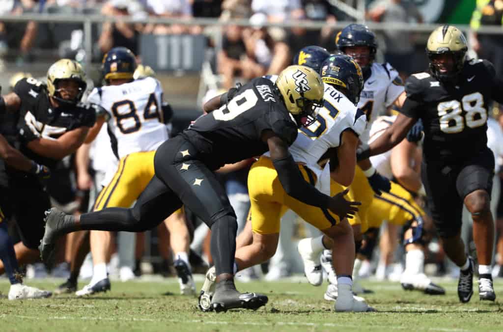 UCF defensive lineman makes a tackle against West Virginia during a Big 12 football game.