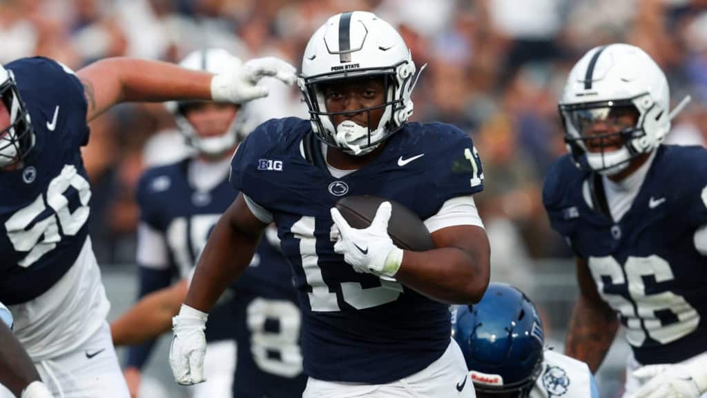 Penn State running back No. 13 powers through traffic with the football secured, featured as a physical back in a 2026 NFL Mock Draft analysis.