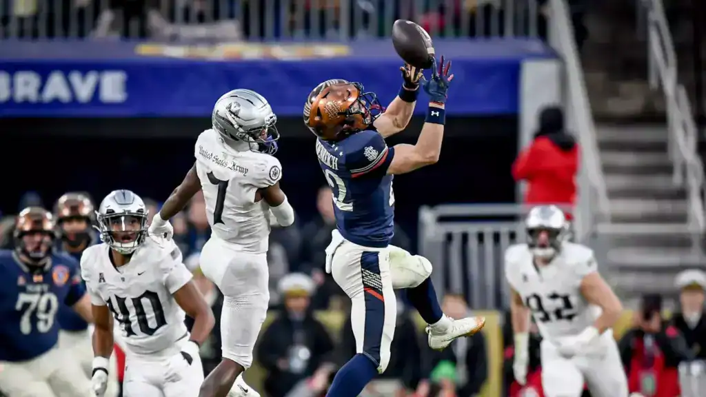 Eli Heidenreich reaches up for a catch while an Army defender closes in during an all-service rivalry game.