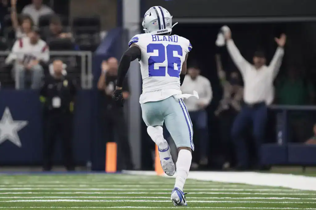 DaRon Bland of the Dallas Cowboys runs toward the end zone after a defensive takeaway during an NFL game at AT&T Stadium.
