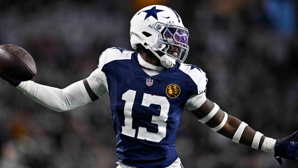 Dallas Cowboys defensive changes featured by a Cowboys defender in a navy No. 13 jersey holding the football.