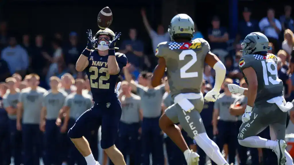 Eli Heidenreich tracks the ball in the air and makes a reception for Navy with defenders closing from the secondary.